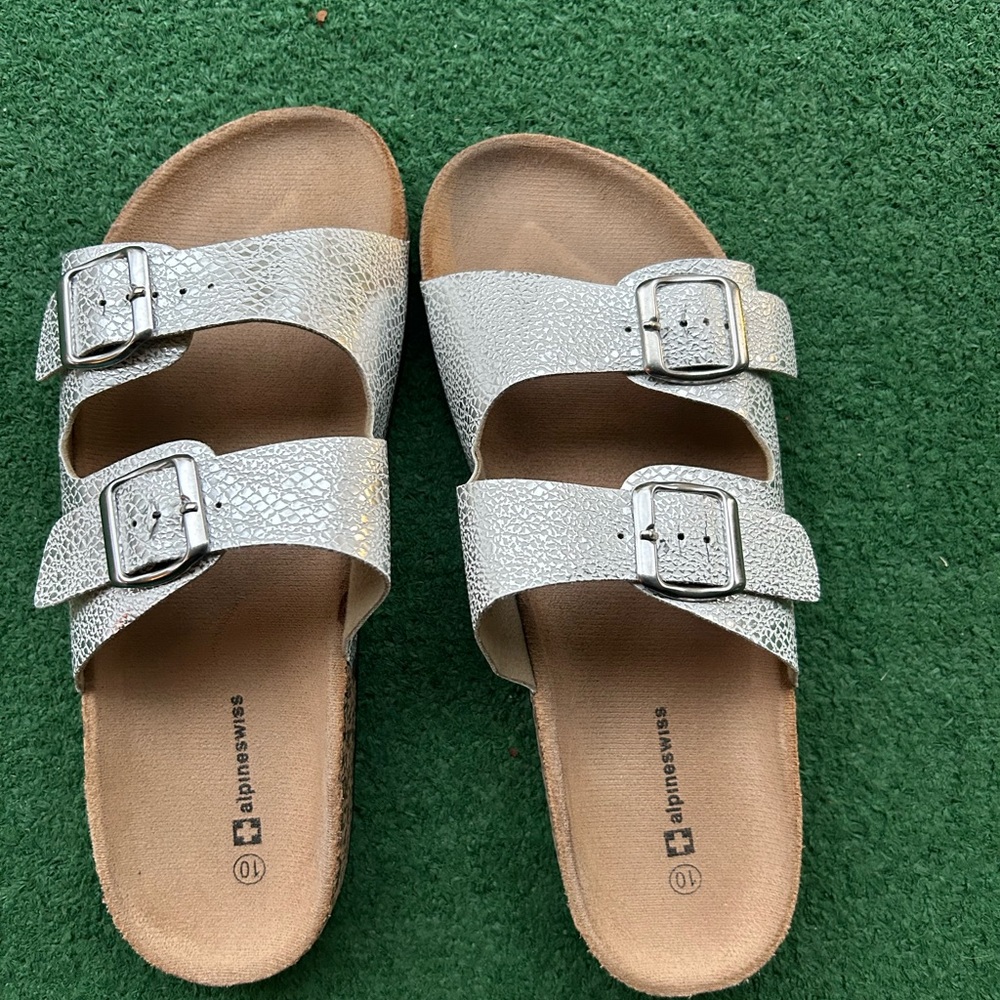 Slide in women’s sandals. Shiny silver in color with nice buckles.